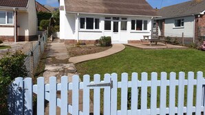 A two-story house with a white exterior, a tiled roof, and a fenced backyard. - Atlantic Retreat - 5 minute stroll from Crooklets Beach (Bude)