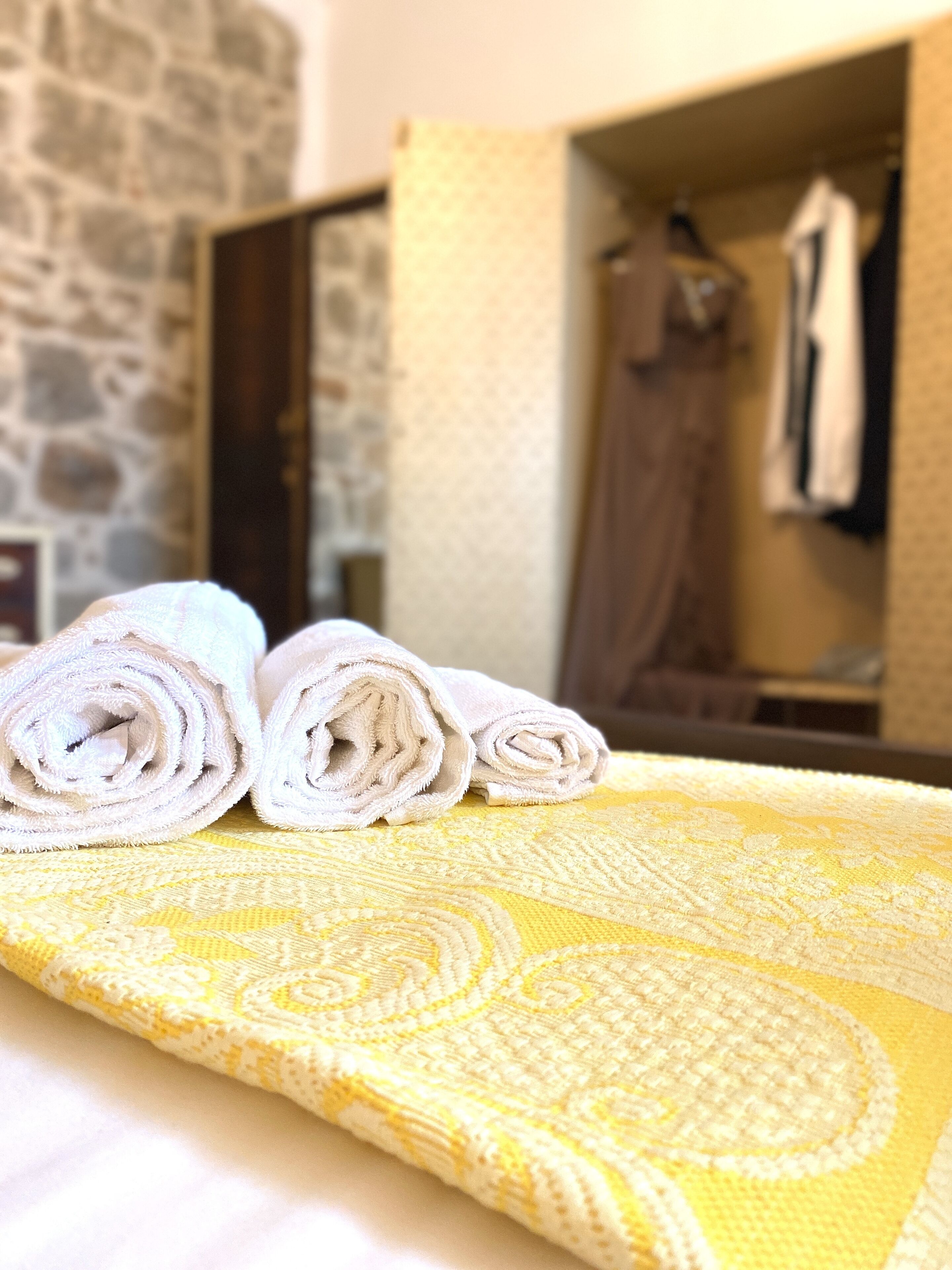 Un lit bien fait, avec des serviettes pliées et une couvre-lit à motifs.
