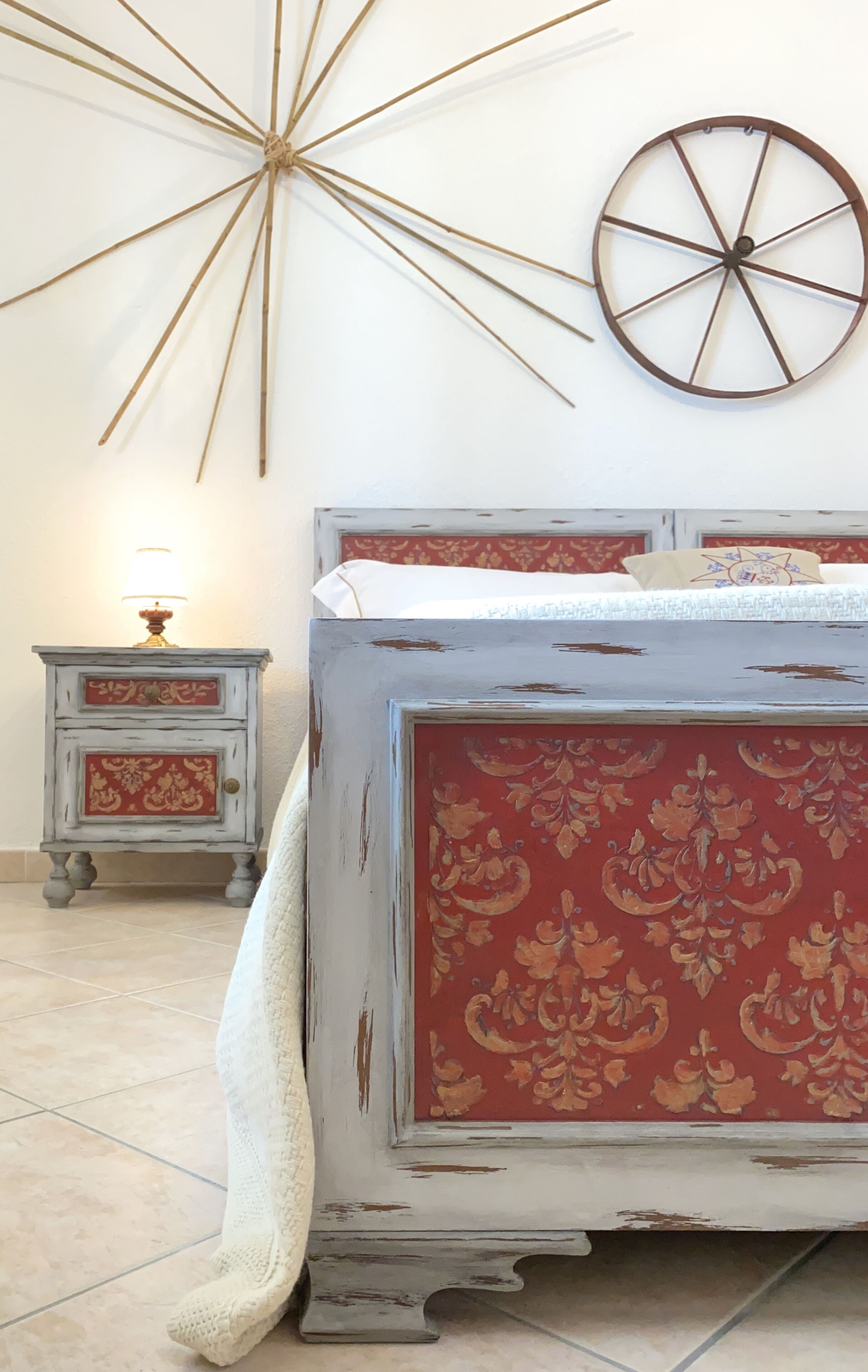 Een slaapkamer met een bed, een nachtkastje, een wandklok en een decoratief object aan de muur.