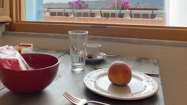 A dining table with a plate, a glass, a bowl, and a fork. - Canduleri (Orgosolo)