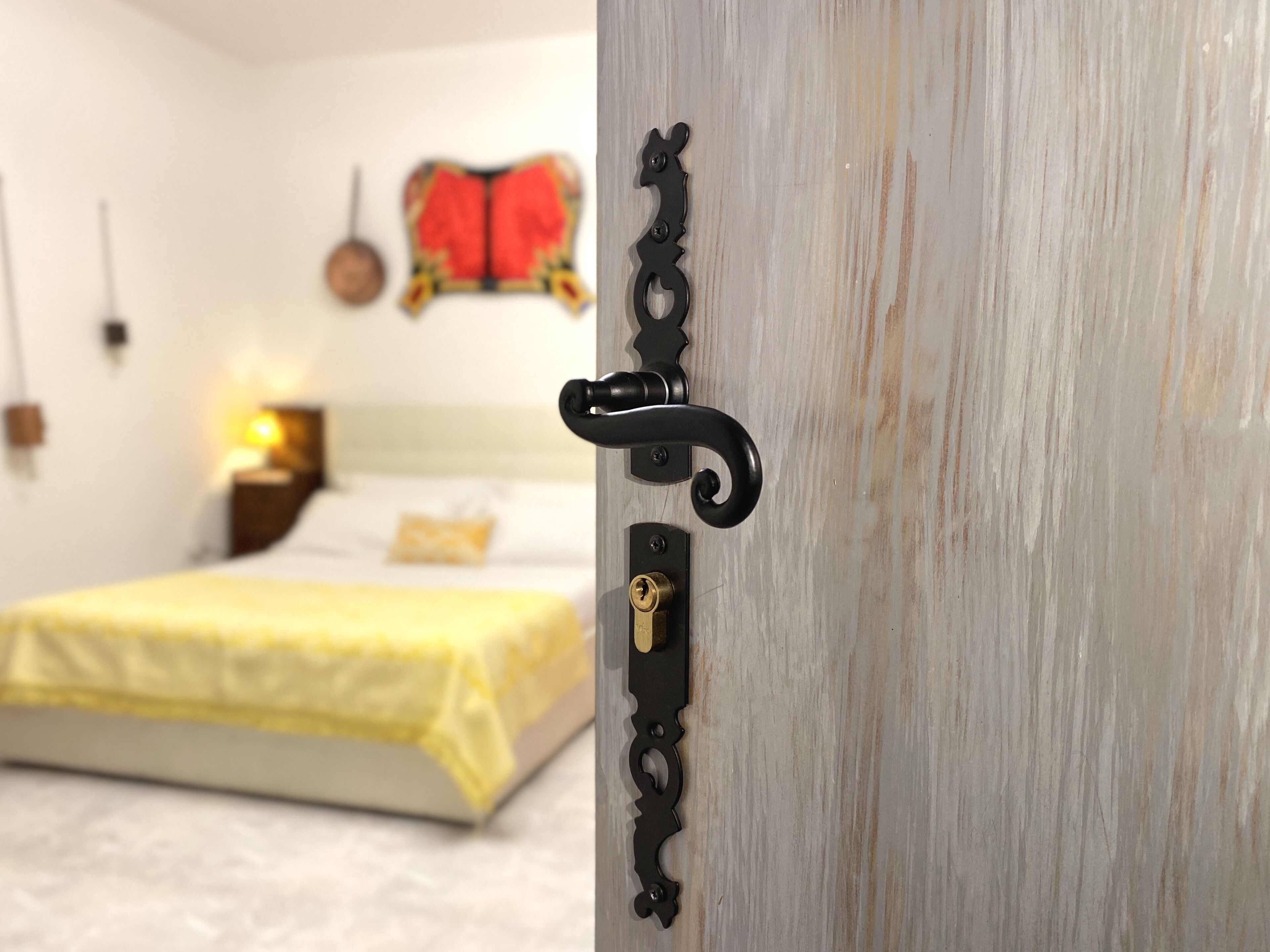 A bedroom with a bed, a nightstand, and a wall-mounted lamp.