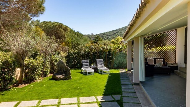 A well-maintained garden with a patio area, stone pathway, and outdoor furniture. - Villa marta, just 100 m from Cala Caterina (villasimius)