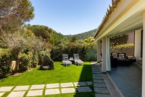 A well-maintained garden with a patio area, stone pathway, and outdoor furniture. - Villa marta, just 100 m from Cala Caterina (villasimius)