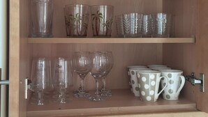 A kitchen cabinet with various glassware and mugs. - minerva 1 bedroom ap (Benalmádena)