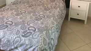 A bedroom with a bed, two nightstands, a lamp, and three wall-mounted flower paintings. - minerva 1 bedroom ap (Benalmádena)