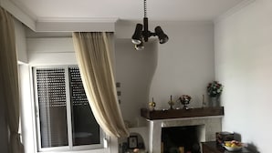 Una sala de estar con chimenea, repisa de piedra, mesita de madera y sofá.