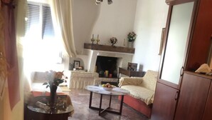 Una sala de estar con chimenea, un sofá, una mesa de centro y un aparador.