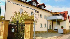 A building with a sign reading "Ferienwohnungen Königsgarten." - Would you like to experience a vacation in the heart of the Palatinate on the German Wine Route? (Deidesheim)