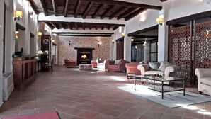 Uma sala de estar ampla com lareira, várias opções de assento e um separador decorativo.