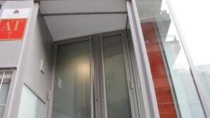 A building entrance with a glass door and a sign above it. - Apartamentos Funway Hostel (Madrid)