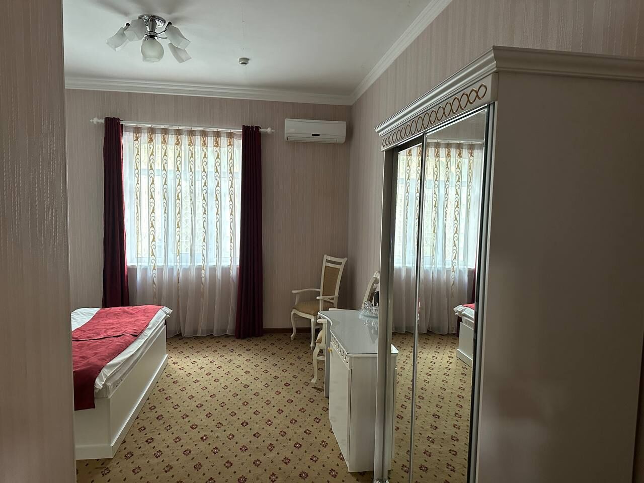 Ein Hotelzimmer mit Bett, Schreibtisch, Stuhl und Kleiderschrank.