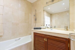 Een bad/douchecombinatie, een bidet, handdoeken