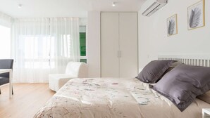 Une chambre à coucher avec un lit, une chaise, une armoire et un radiateur.