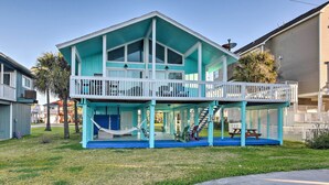 Een tweelaags huis met een balkon, een hangmat en een picknicktafel.
