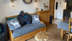 Ein gemütliches Wohnzimmer mit einer Couch, einem Esstisch und einer Küchenzeile.