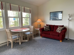 Relax in this inviting living room with a sofa, round table, and floor lamp.