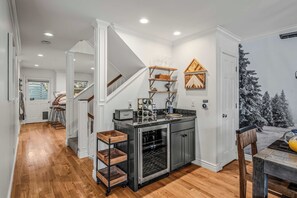 A kitchen with a built-in oven, a wine cooler, and a coffee machine.
