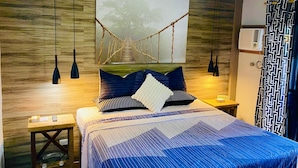 Ein Schlafzimmer mit einem Bett, einem Holzkopfstück, einem Gemälde einer Brücke und Pendelleuchten.