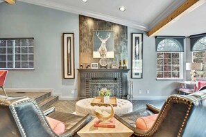A living room with a fireplace, leather furniture, and artwork on the walls.