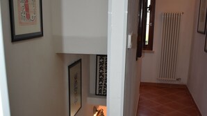 A staircase with a handrail, a radiator, and framed artwork on the walls.