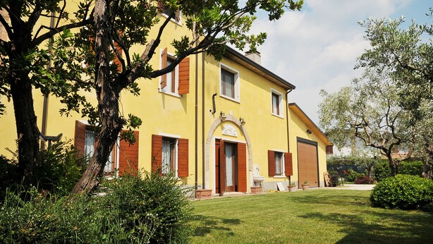 A yellow building with a large front door, a garage, and a well-maintained lawn.