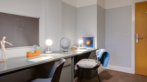 A study room with a desk, chairs, a globe, a whiteboard, and a door. - Griffith Rooms (Dublin)