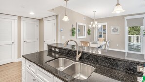 Una cocina moderna con encimera de granito, pileta de acero inoxidable e iluminación colgante.