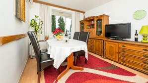 Un comedor con una mesa redonda, sillas y alfombra roja.