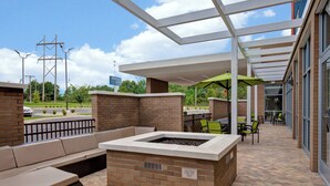 An outdoor patio area with a fire pit, seating, and tables. - SpringHill Suites by Marriott Orangeburg (Orangeburg)