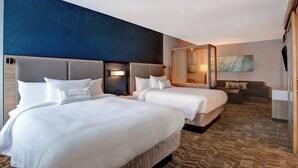 A hotel room with two beds, a seating area, and a large abstract painting on the wall. - SpringHill Suites by Marriott Orangeburg (Orangeburg)