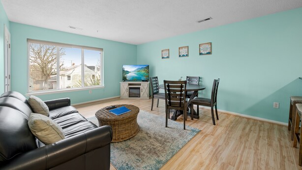 A living room with a sofa, coffee table, TV, and dining area.