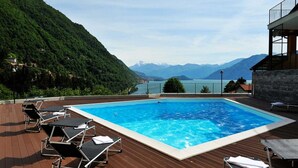 Une piscine avec des chaises longues et une vue sur les montagnes.
