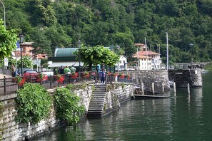 A waterfront area with a stone staircase leading down to a dock. - Residence Eden Camelia 5 (Argegno)