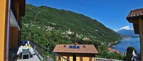 A balcony with a view of a mountainous landscape and a lake.