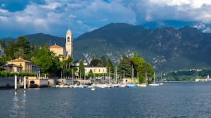 A waterfront view with a church, boats, and mountains in the background. - Villa Tremezzo (Tremezzina)