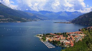A coastal town with a marina, mountains in the background, and clear skies. - Bellano Perla Apt. 8 (Bellano)