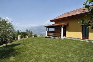 A house with a covered patio, a well-maintained lawn, and a mountain view in the background. - Sogni Di Bellagio ICI (Bellagio)