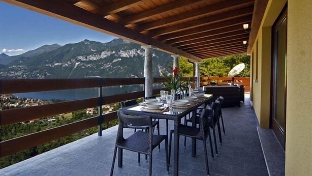 A terrace with a table set for dining, overlooking a mountainous landscape. - Sogni Di Bellagio ICI (Bellagio)