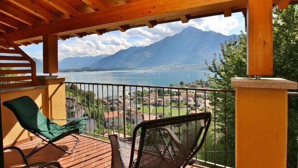 A wooden deck with a view of a lake and mountains. - Residenza Vercana Giardino (Vercana)
