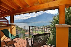 A wooden deck with a view of a lake and mountains. - Residenza Vercana Giardino (Vercana)