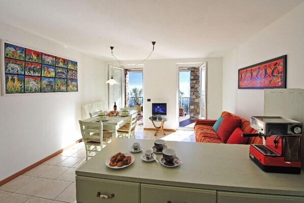 A spacious living area with a dining table, a coffee machine, and a TV.