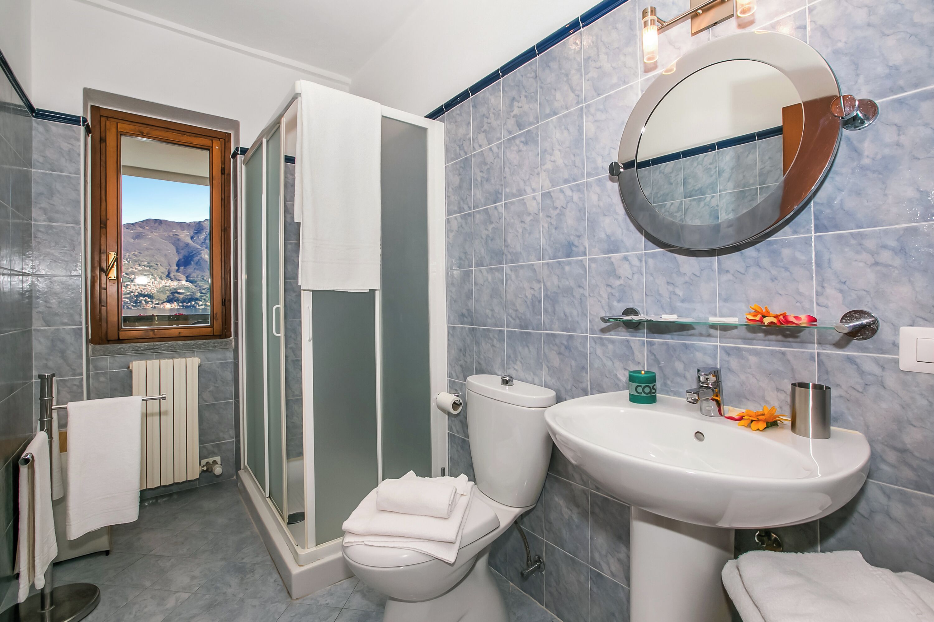 Een badkamer met toilet, wastafel en douche.