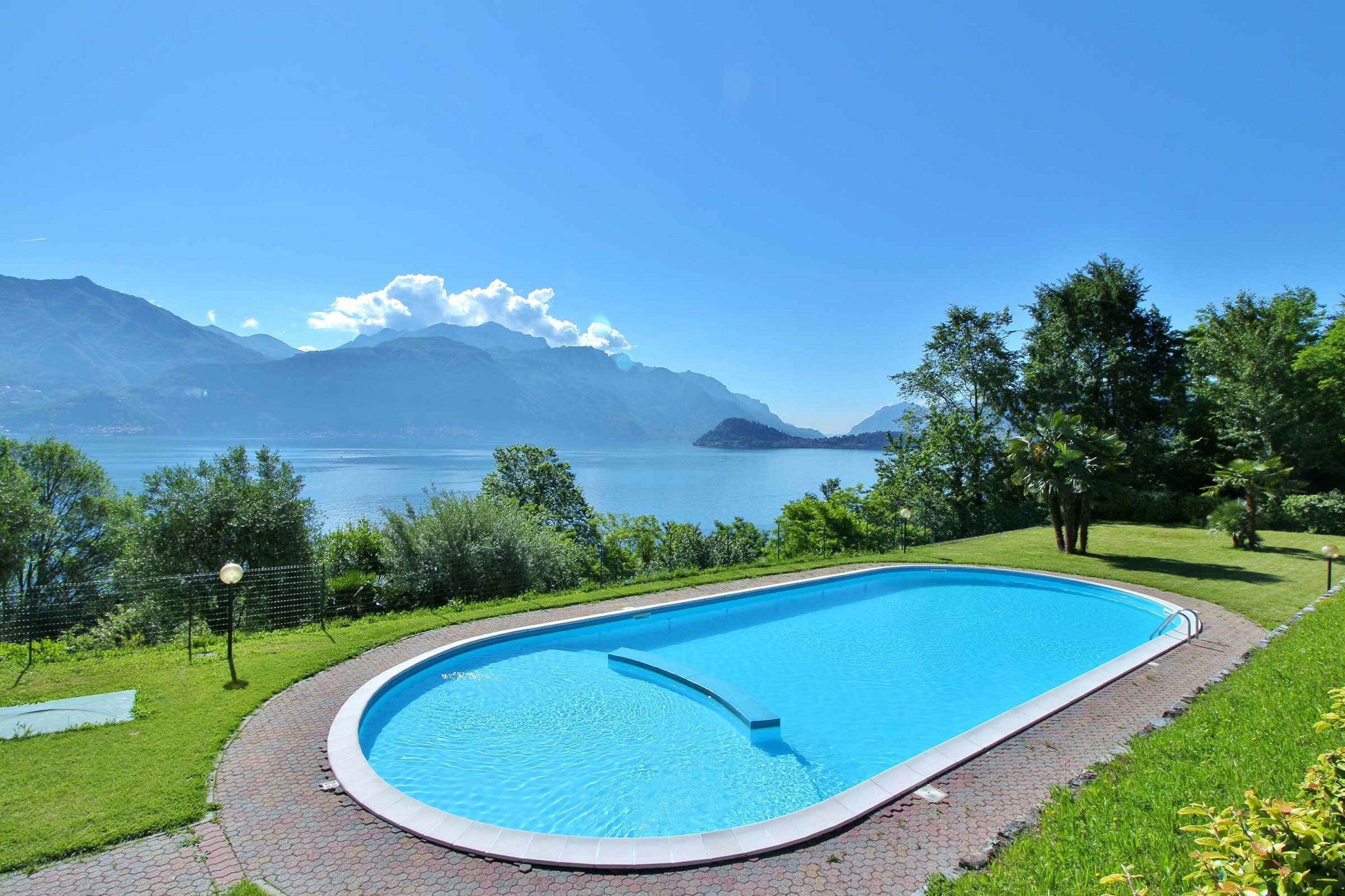 Una piscina con vistas a montañas y un lago.