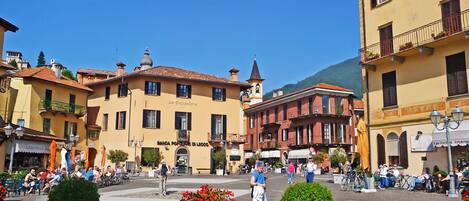 A square with buildings, outdoor seating, and potted plants.