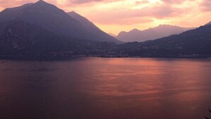Un paisaje montañoso con un lago tranquilo y un pueblo en el valle.