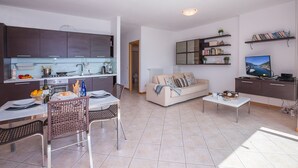 Un apartamento moderno con cocina, comedor, sala de estar y televisor.