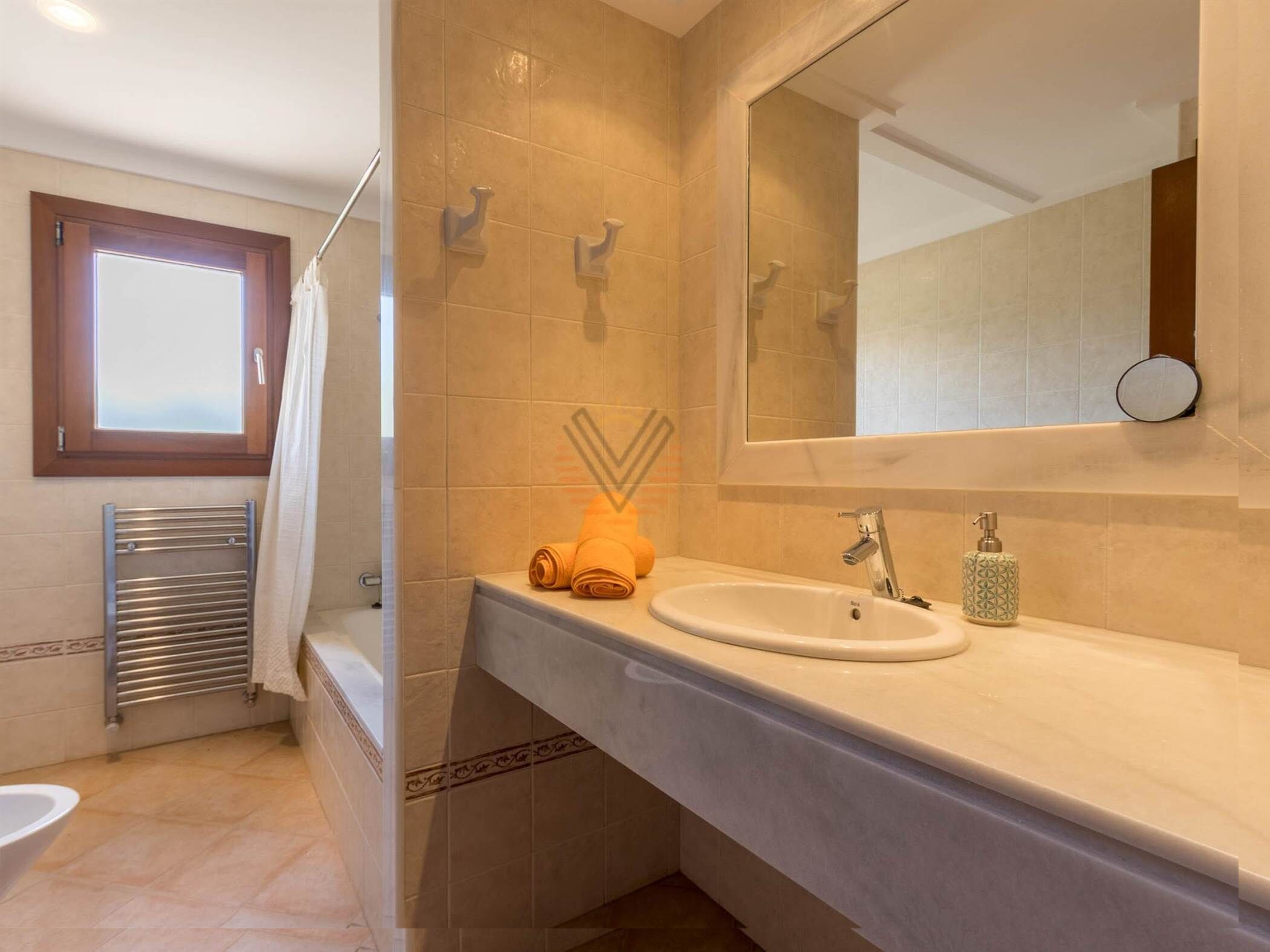 Une salle de bain moderne avec un grand miroir, un lavabo et un porte-serviettes.