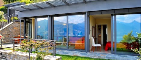 Una casa moderna con amplios ventanales, una escalera de piedra y un jardín.