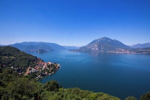 A coastal town with a mountain backdrop, a clear blue sky, and calm waters.