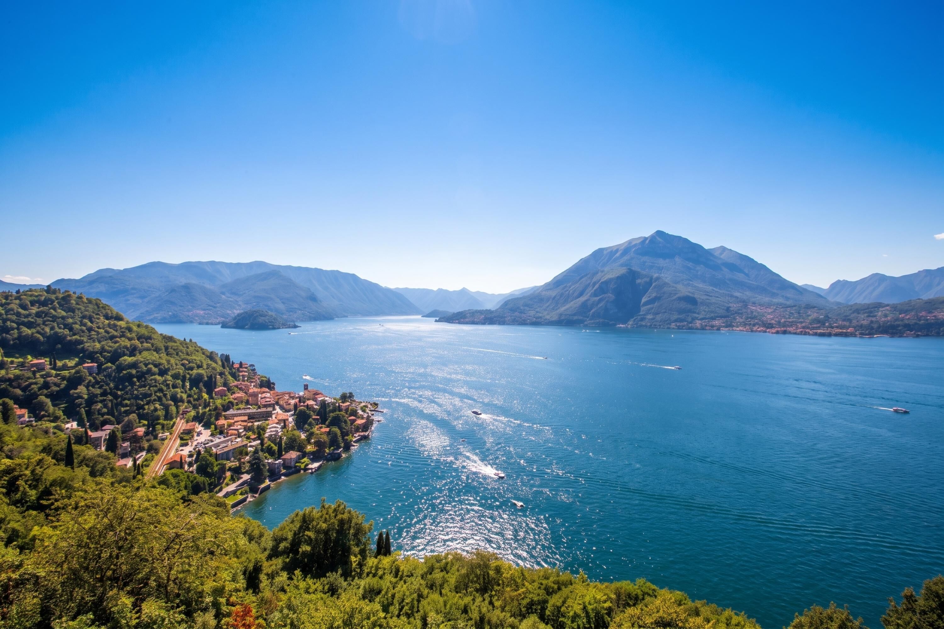 A lake surrounded by mountains with a town on the shore.